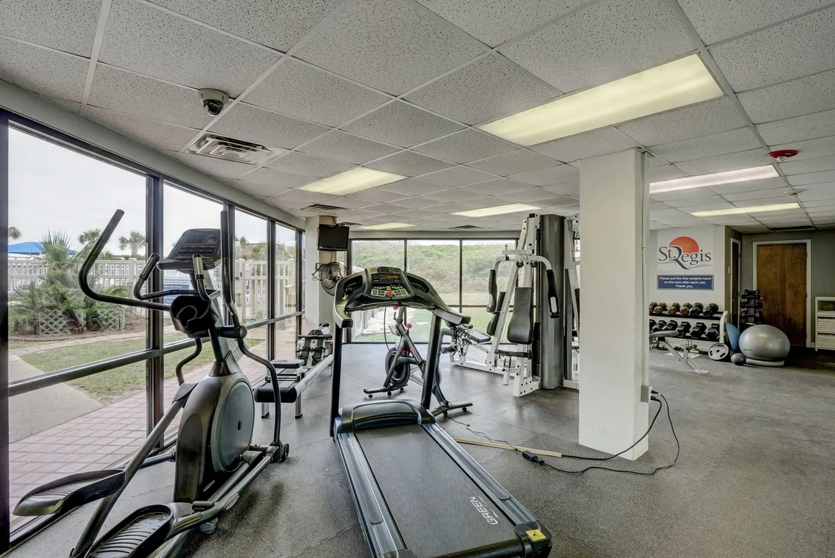 A bright, well-equipped fitness center featuring a treadmill, elliptical machine, and weight training equipment. The space is modern and motivational, designed for a variety of workouts and community fitness activities.